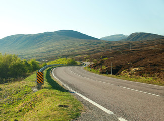 country road winding through the Scottish highlands.