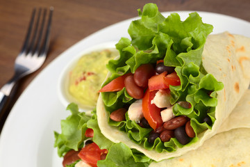 Mexican tortilla wraps with chicken, beans, lettuce, tomato