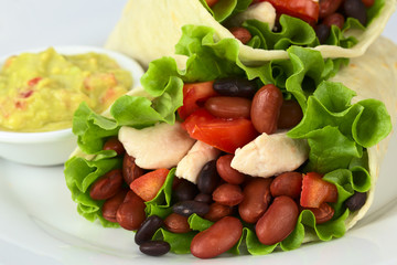 Mexican tortilla wraps with chicken, beans, tomato, lettuce