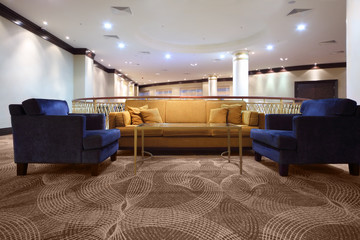 Comfortable divan and two armchair inside lighting hall