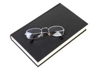 book with reading glasses over white background