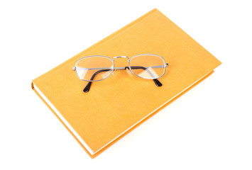 book with reading glasses over white background