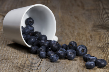 blaubeeren rollen aus umgekippter tasse