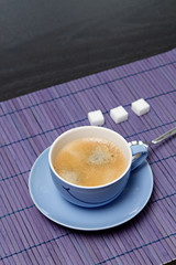 Cup of coffee on the purple table mat