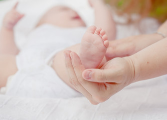 Obraz na płótnie Canvas parental hand holds legs of the baby