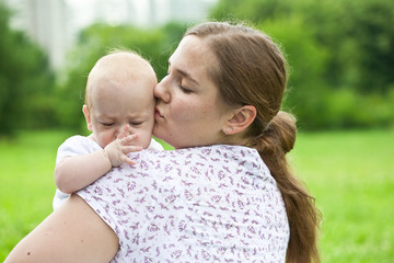 Young mum walks with the child in city park