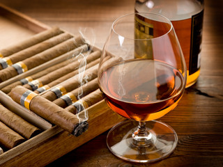 cuban cigar and bottle of cognac on wood background - obrazy, fototapety, plakaty