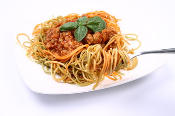 Spaghetti bolognese on a plate being eaten with a fork