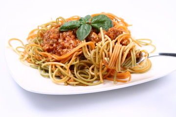 Spaghetti bolognese on a plate being eaten with a fork