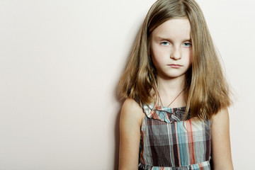 Sad little girl with long blond hair.