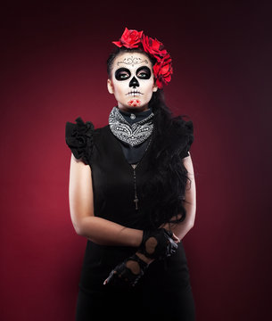 Serious woman in day of the dead mask on red