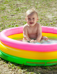 Happy baby swimming  in  inflatable pool