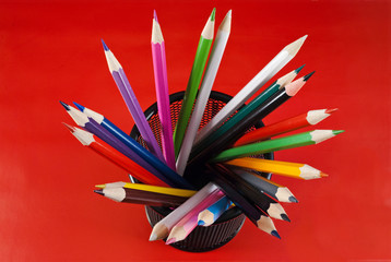 Colored pencils in a black mesh holder.