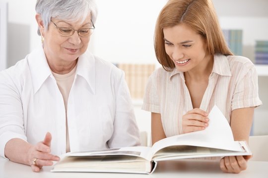 Senior mother and daughter looking at photo album