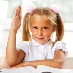 Portrait of a young girl in school at the desk.