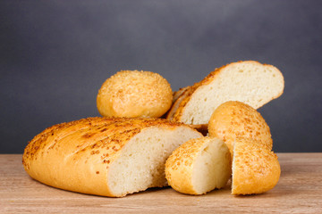 white bread and buns on wooden table on gray background