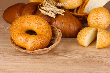 rye and white bread and buns on wooden background