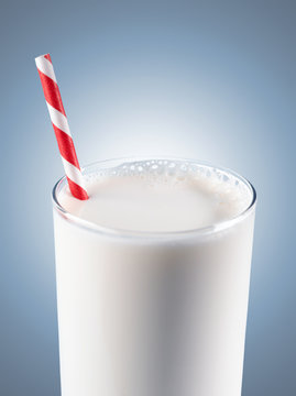 Glass of milk with striped red straw