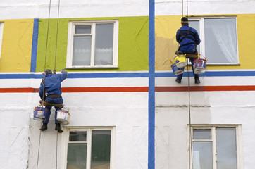 House painters paint the facade of building