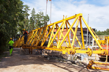 Setting up a tower crane.  The jib is erected in ground.