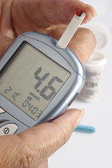 A diabetic looking at a reading on a glucose level monitor
