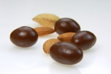 Almonds and almond candy on white background