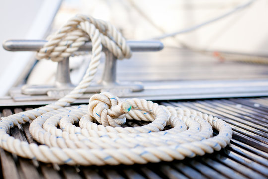 Fototapeta Mooring rope with a knotted end tied around a cleat.