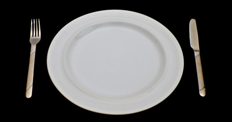 Empty white plate with knife and fork