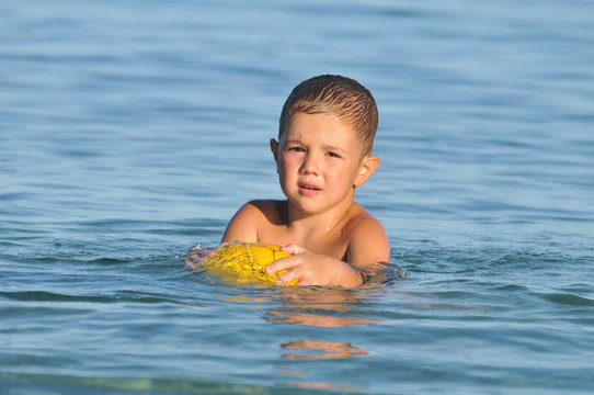 boy with a ball in the water