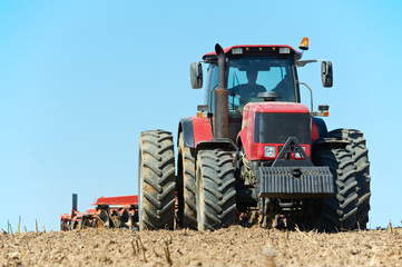 Ploughing tractor at field cultivation work