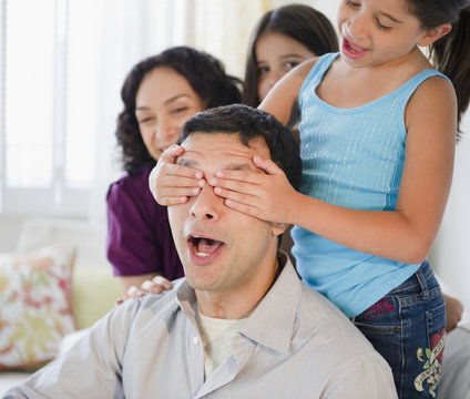 Daughter covering surprised father’s eyes