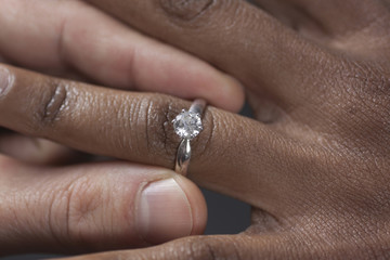 Close up of man putting engagement ring on girlfriend