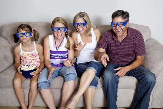 Caucasian watching television with 3-d glasses