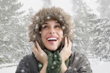 Mixed race woman in fur hood watching snow fall