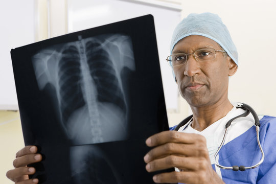 Mixed race surgeon looking at x-rays