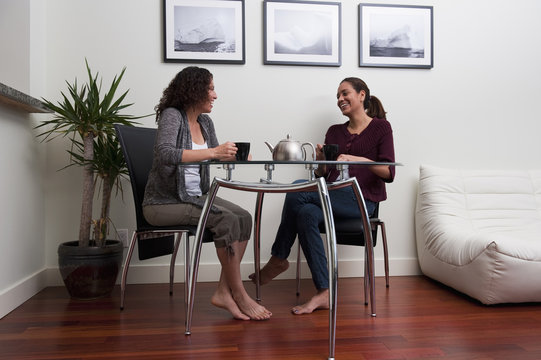 Hispanic women talking and drinking coffee