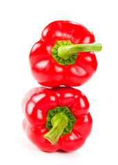 two fresh red peppers on white