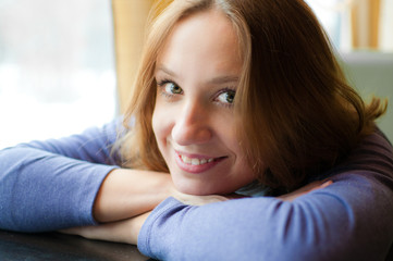 Pretty young woman leaning on a table