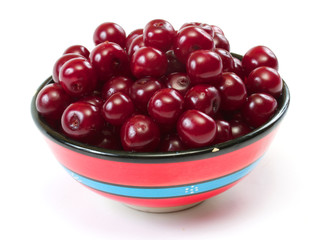 Bowl with ripe cherries. Isolated on a white background.