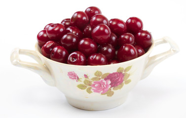 Bowl with ripe cherries. Isolated on a white background.