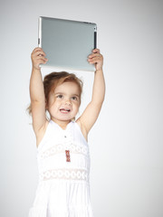 Adorable little girl is playing with touchpad