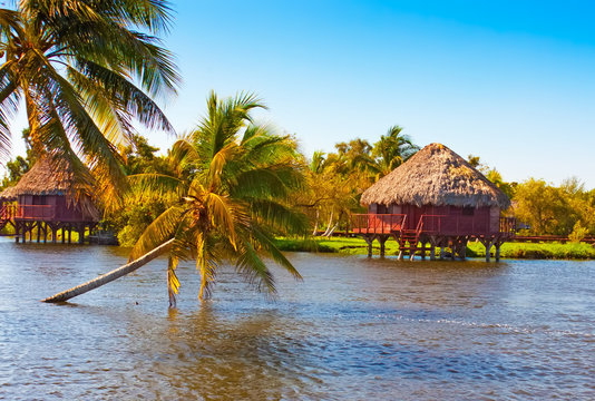 Traditional thatched houses on a lake in Cuba