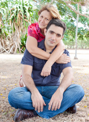 Latin mother hugging a young man on a  park
