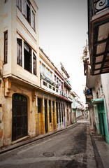 Fototapeta na wymiar Street in Old Havana sidelined by colorful crumbling buildings