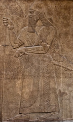 Ancient assyrian clay relief depicting a warrior with a sword a
