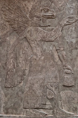 Ancient assyrian clay relief depicting an eagle-faced god