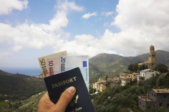 Man’s hand holding passport and euro currency