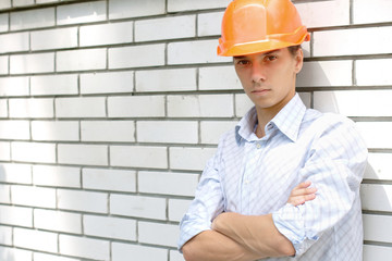 Young worker standing near a white wall with copy space