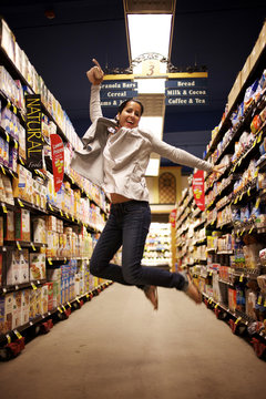 Hispanic woman jumping in grocery store