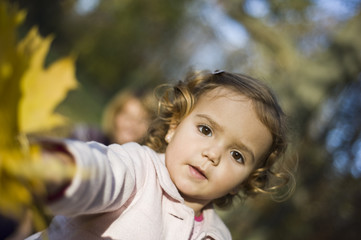 Fototapeta premium Little girl in the park in autumn